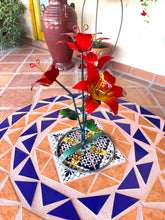 Load image into Gallery viewer, Red lily metal bouquet garden decor with green stems and leaves, displayed on a blue and beige mosaic tile table.