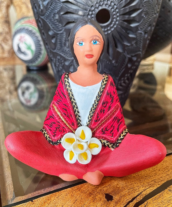 clay doll selling flowers red shawl